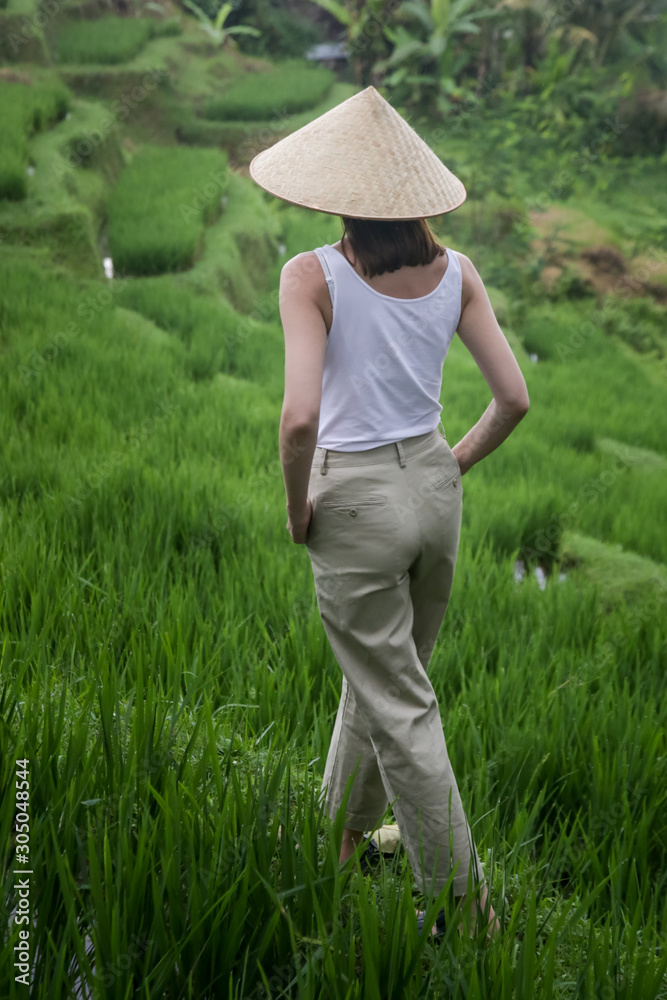 Woman wearing traditionl bamboo hat on the rice field terrace