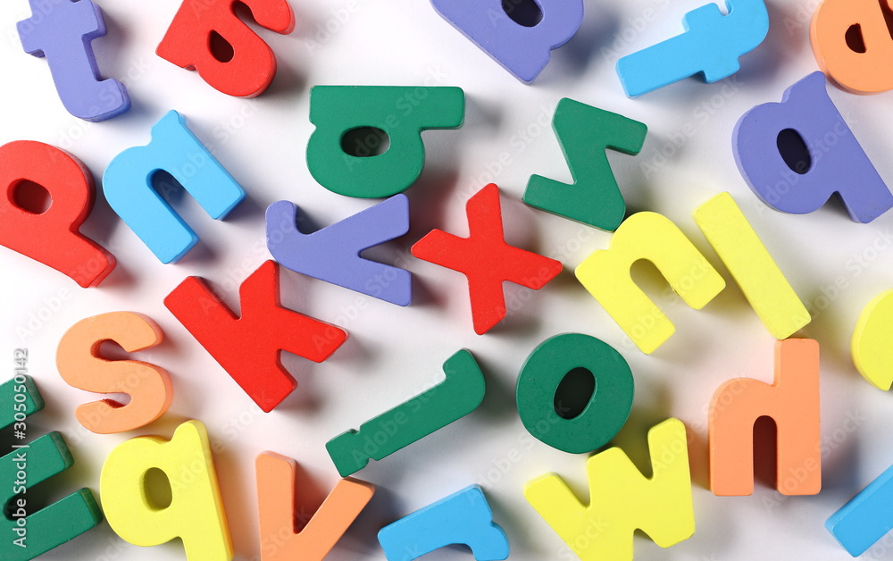 Naklejka premium Colorful wooden alphabet letters isolated on white background and texture, top view