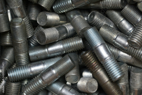 Studs or threaded steel rods closeup background. Industrial background.
