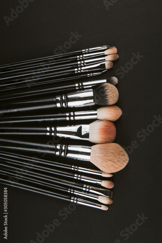 Isolated make-up powder with brush on black background
