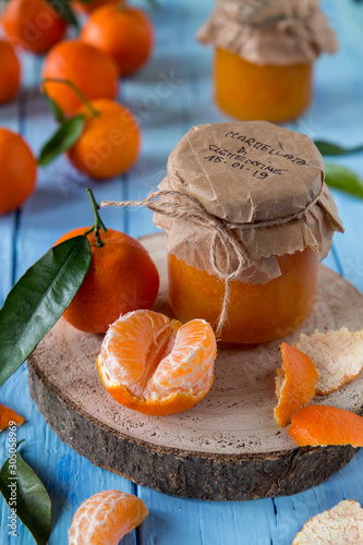 Barattolo di marmellata di clementine e frutta fresca sparsa photo