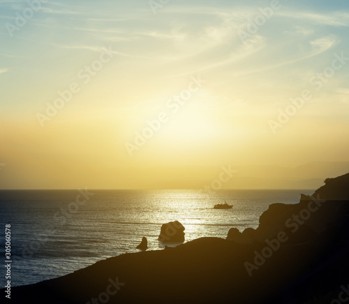 rocky sea coast silhouette at the sunset, evening marine background © Yuriy Kulik