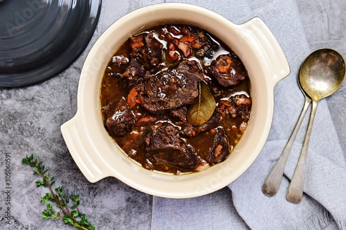 Beef bourguignon in the pot on the grey background, top view