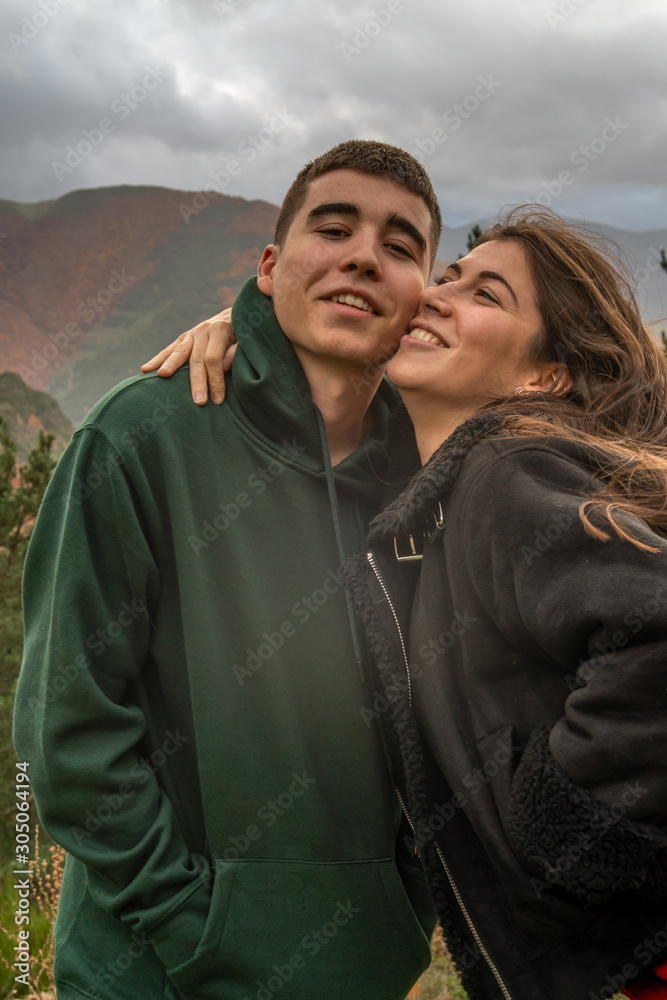 girl and boy in a hug next to the mountain of beeches in autumn girl and boy in a hug next to the mountain of beeches in autumn
