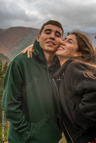 girl and boy in a hug next to the mountain of beeches in autumn