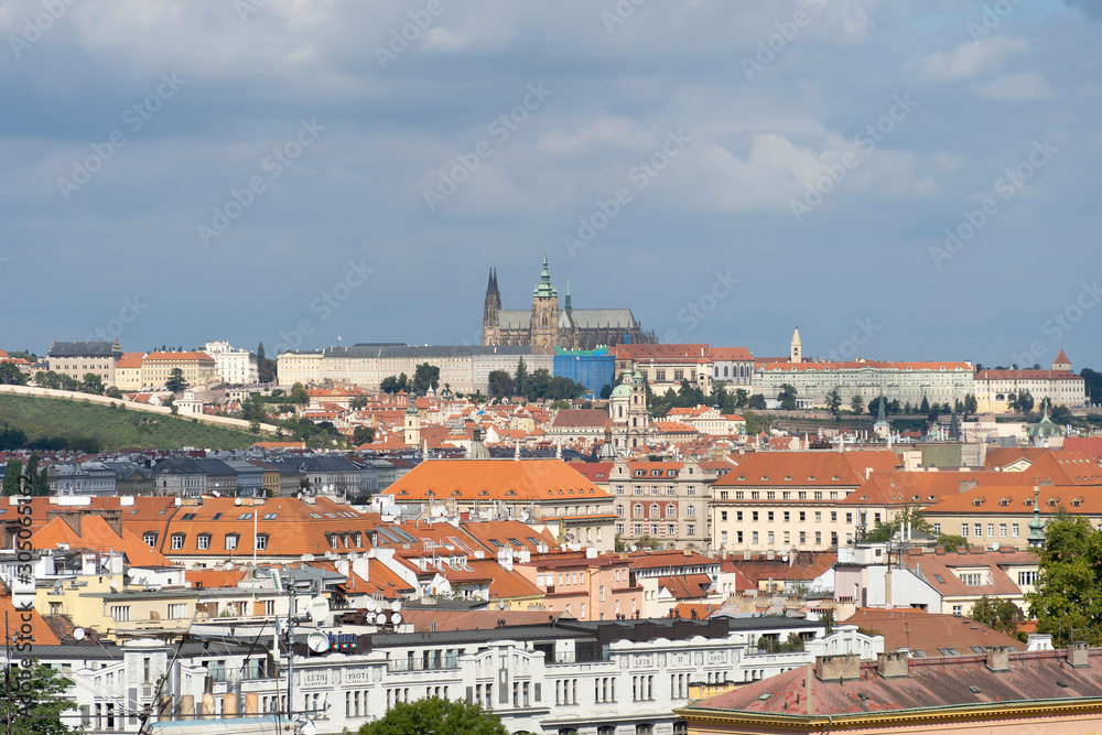 Red roofs in the city of Prague. View of the palace, blue sky, sunny day. A beautiful city for leisure and travel.