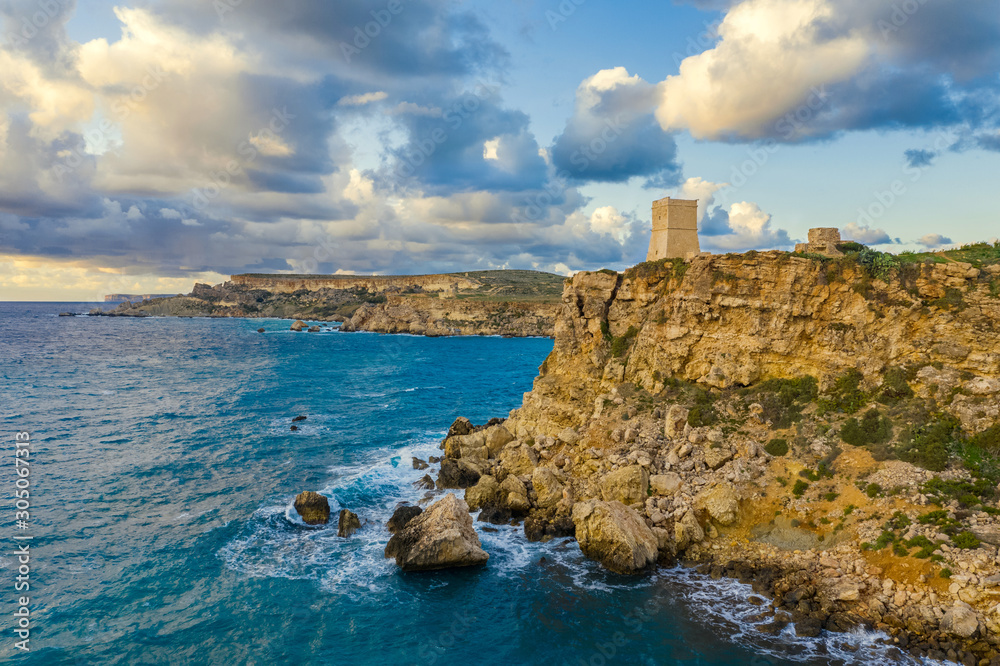 Ghajn Tuffieha Tower. Aerial view from the sea, sunset, cloudy blue sky. Malta country