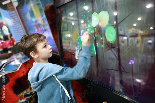 Kid playing game on touchscreen