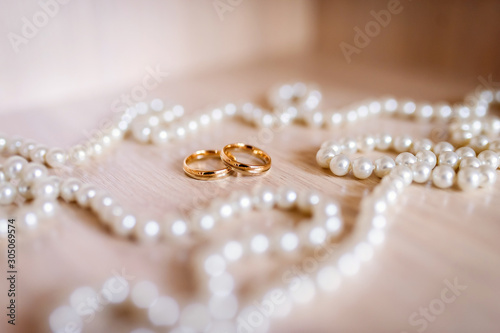Wedding background. Wedding rings near the pearl lace. Wedding concept. Closeup.