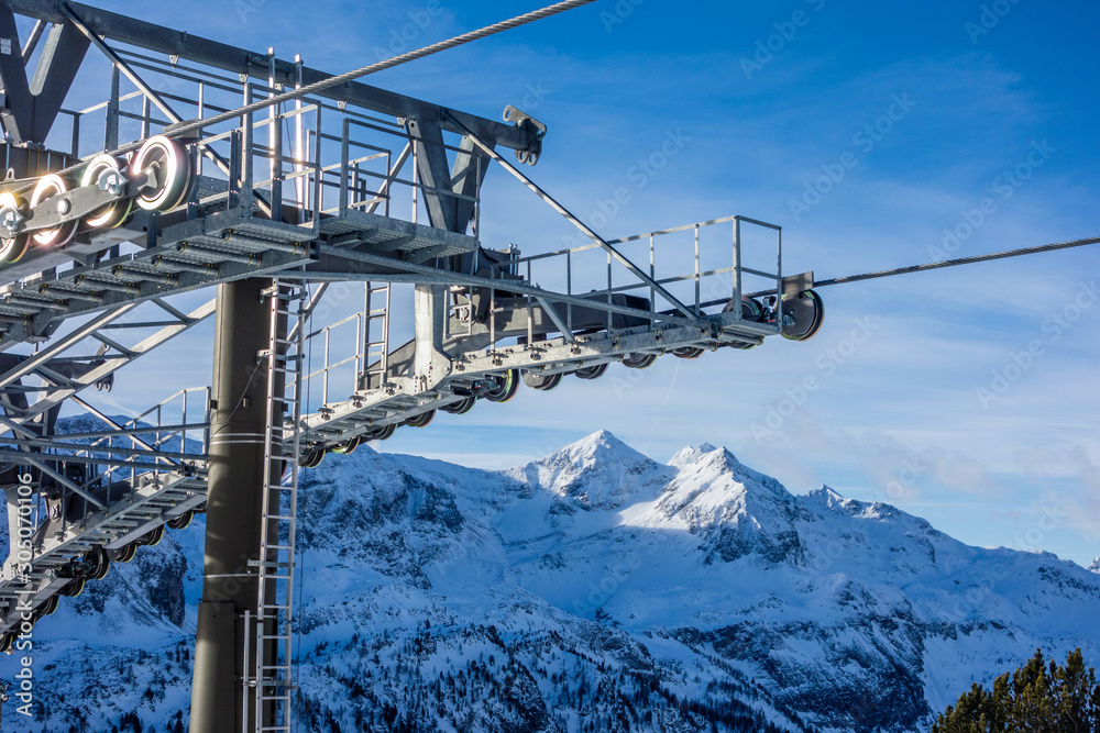Ski lift detail with alpine snowy peaks in distance, Obertauern, Austria, Europe Ski lift detail with alpine snowy peaks in distance, Obertauern, Austria, Europe