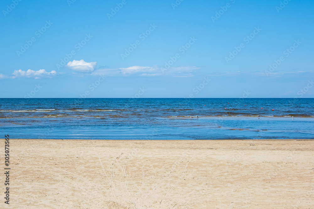 Three colors of Jurmala: golden sand on Dzintari, deep blue of Baltic sea and azure of Latvian sky.  Famous Dzintari beach in Jurmala, Latvia