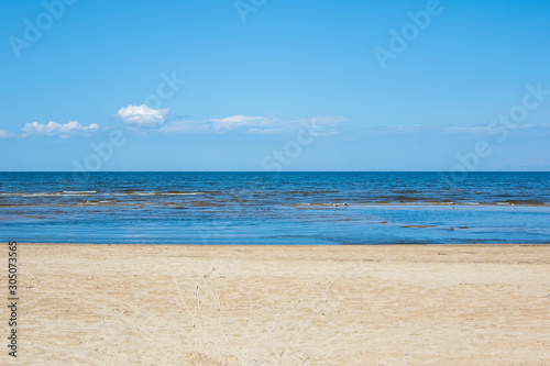Three colors of Jurmala: golden sand on Dzintari, deep blue of Baltic sea and azure of Latvian sky. Famous Dzintari beach in Jurmala, Latvia