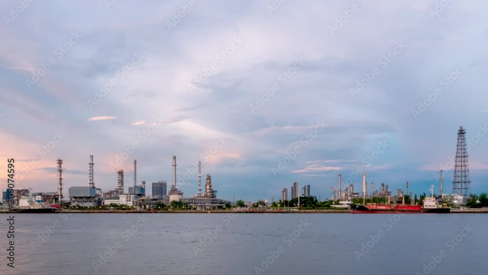 Oil refinery petrochemical and energy industry with refection on river, day to night, zoom out - Time-lapse Oil refinery petrochemical and energy industry with refection on river, day to night, zoom out - Time-lapse
