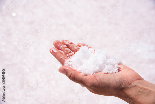 Close up shot of female hand holding salt at dry salt lake Tuz in Turkey.
