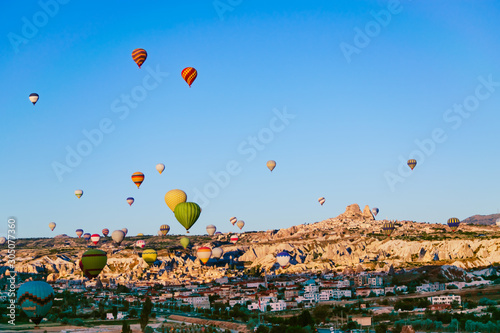Hot air balloons flying in over Goreme, Cappadocia, view from red valley.