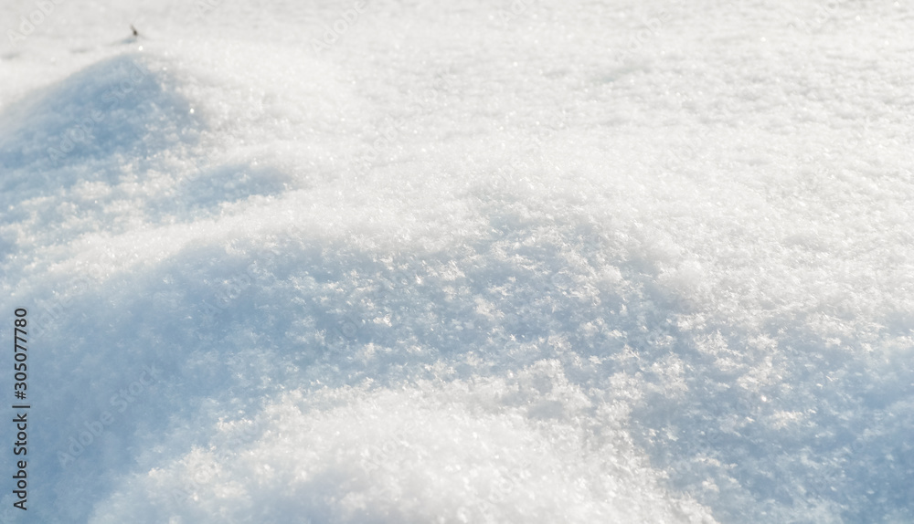 Hilly surface covered with fresh snow in the garden on a sunny day. Natural winter background. Hilly surface covered with fresh snow in the garden on a sunny day. Natural winter background.