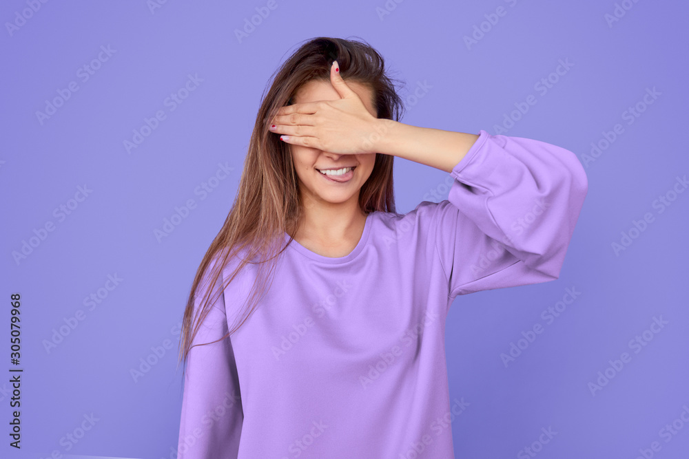 Funny woman covering eyes and biting tongue Funny woman covering eyes and biting tongue