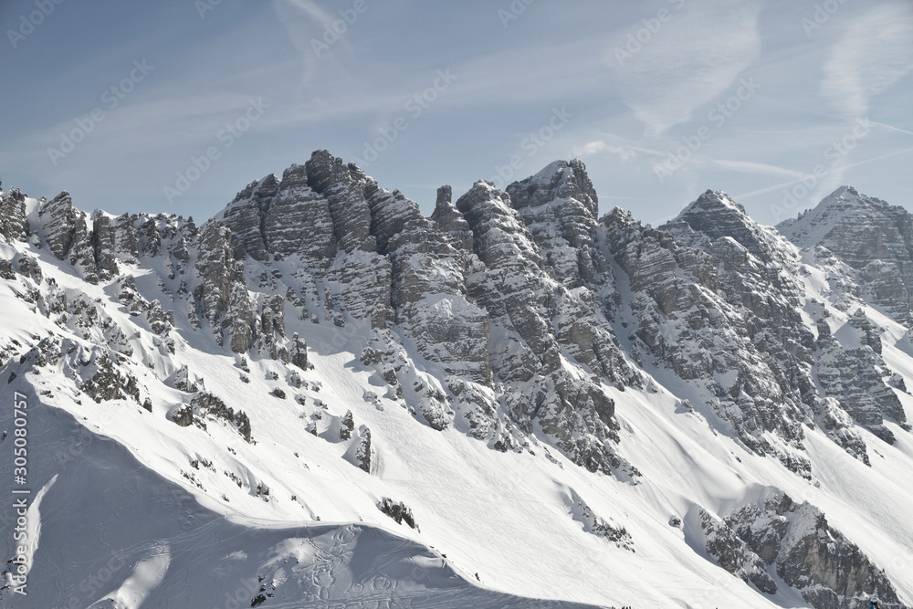 Ski Tour in der Axamer Lizum in Tirol mit Spuren und schneebedeckten Bergen zum Gipfel. Neuschnee im Winter. Steile Berghänge