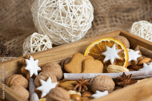 christmas cookies and spices on wooden background