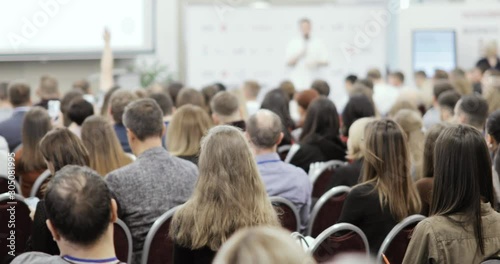 Seminar, meeting, training, conference in group. Public speech concept. Educational finance lectures for startuppers. Business training with man speaker talking in large audience, view from viewers.