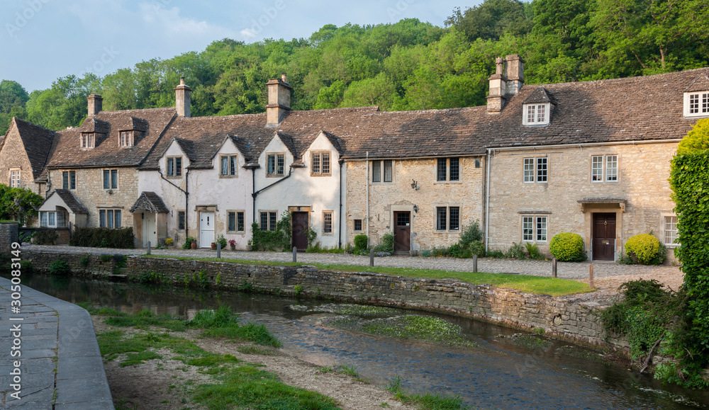 CASTLE COMBE, COTSWOLDS, UK - MAY 26, 2018: Street view of old riverside cottages in the picturesque Castle Combe Village, Cotswolds, Wiltshire, England - UK