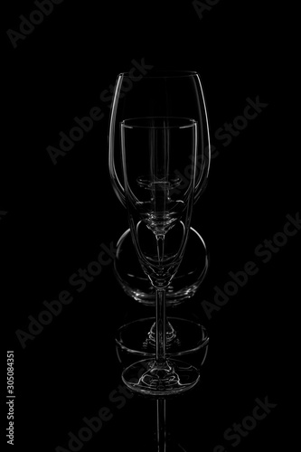 Empty clean glass glasses stand in a row against a black background.