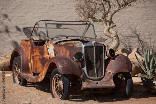 Abandoned old rusty wrecked historic car near a service station at Solitaire in Namibia desert ear the Namib-Naukluft National Park.