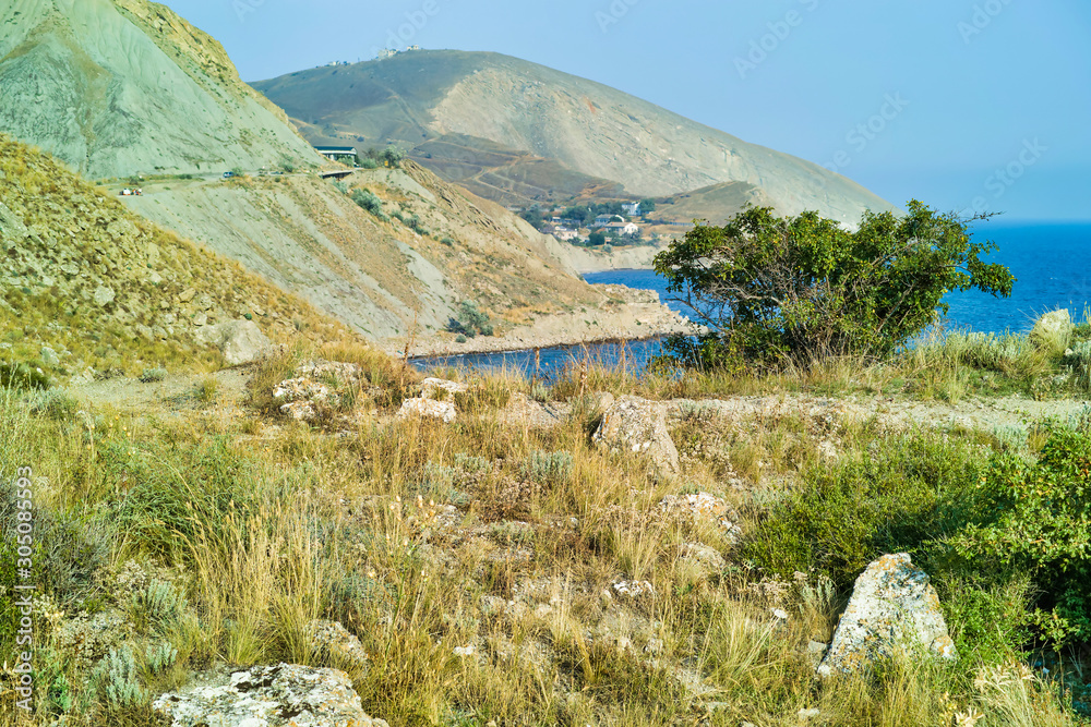 Cape Black sea in the village of Ordzhonikidze in the Crimea, in the summer with a textured sky with clouds. And hilly terrain, landscape