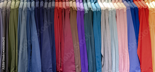 Close up of Multi colored shirts on hangers, Colorful apparel cloth background © Naypong Studio