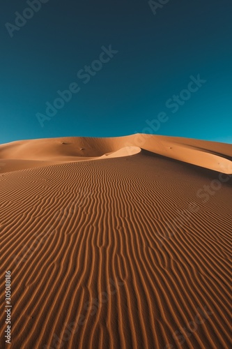 Vertical shot of a peaceful desert under the clear blue sky captured in Morocco Fototapet