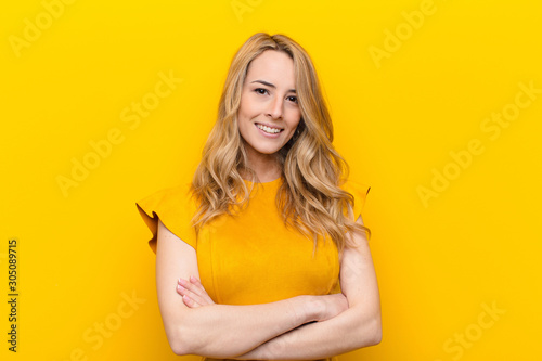 Slika na platnu young pretty blonde woman smiling to camera with crossed arms and a happy, confi