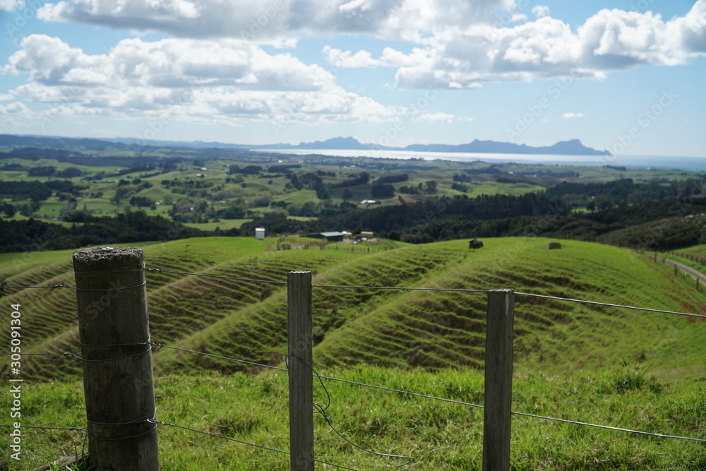 fence in front of farmland hills