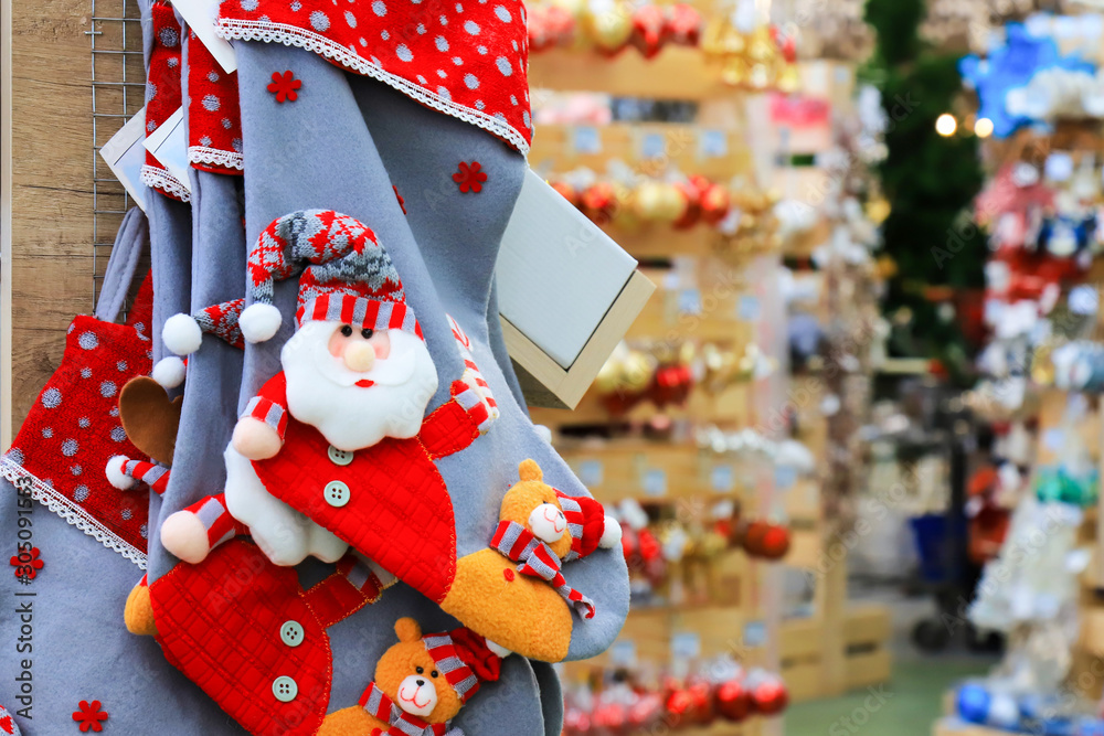 Shelves with funny Santa Claus toys, Christmas and New Year's blue boots and decorations. Positive emotions, joy. Festive New Year's winter trade, a fair in a toy store, shopping