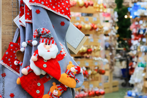 Shelves with funny Santa Claus toys, Christmas and New Year's blue boots and decorations. Positive emotions, joy. Festive New Year's winter trade, a fair in a toy store, shopping