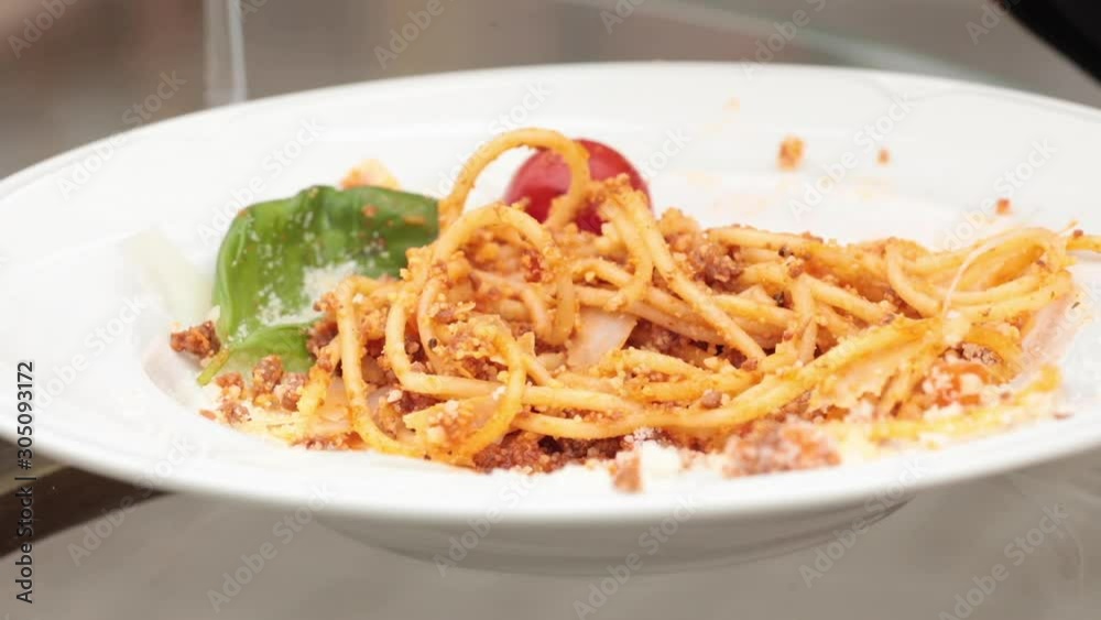 Closeup of of delicious spaghetti with stuffing, parmesan and tomatoes in white plate in restaurant. Fork taking and eating carbonara in cafe. Concept of italian dish, food and enjoyment. Closeup of of delicious spaghetti with stuffing, parmesan and tomatoes in white plate in restaurant. Fork taking and eating carbonara in cafe. Concept of italian dish, food and enjoyment.