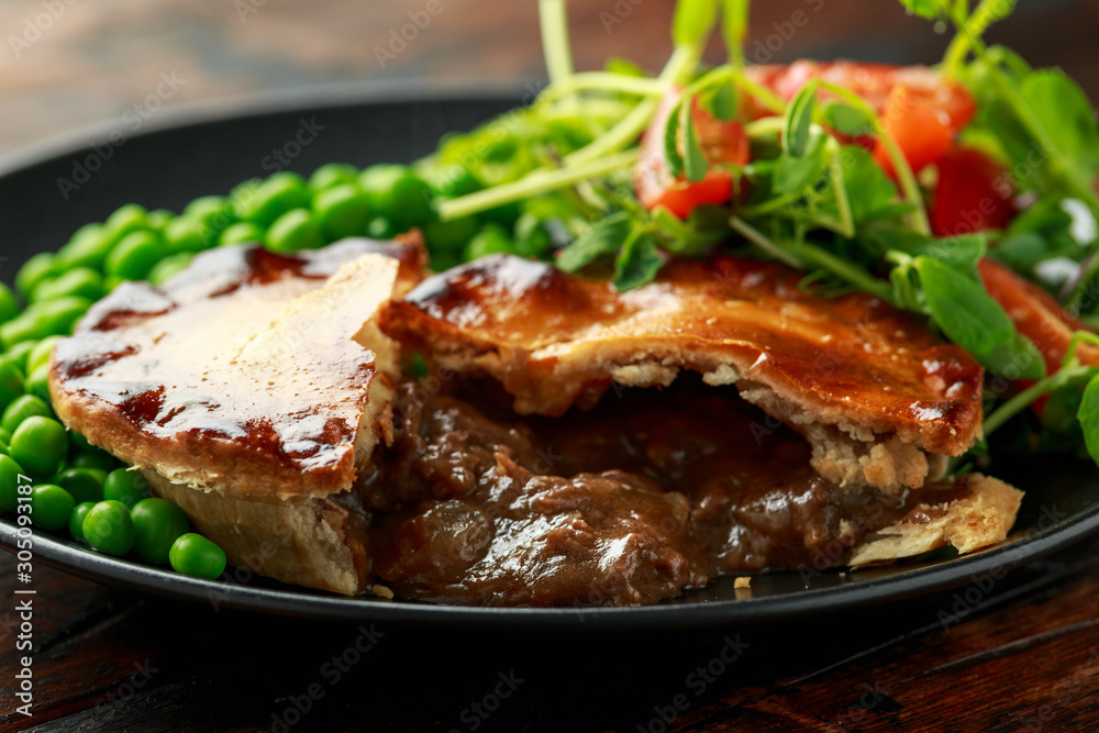 Beef steak pies with rich onion gravy served with sweet peas and salad Beef steak pies with rich onion gravy served with sweet peas and salad