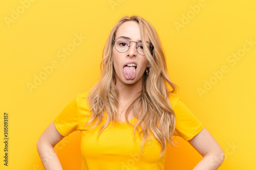 Obraz na plátně young pretty blonde woman feeling disgusted and irritated, sticking tongue out,