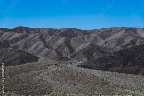 A desert landscape of barren hills of black volcanic rock