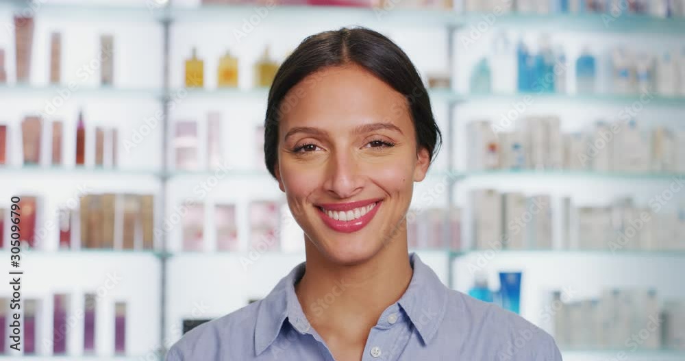An young woman with perfect skin face is smiling in a camera on a background of pharmacy. An young woman with perfect skin face is smiling in a camera on a background of pharmacy.