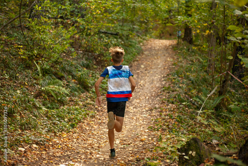 Running competition. A child runs through the forest.