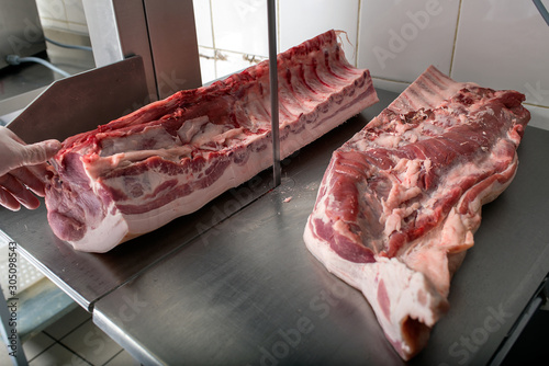 cutting pork with a saw in a butcher shop