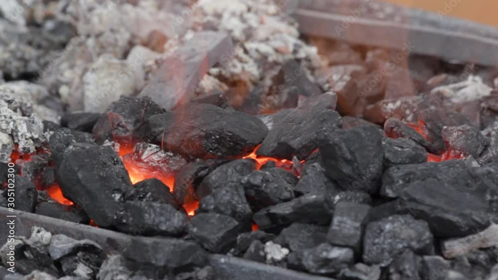Embers glow in a iron forge. Annealing and heat-treating of iron parts for forging. Static camera. Embers glow in a iron forge. Annealing and heat-treating of iron parts for forging. Static camera.