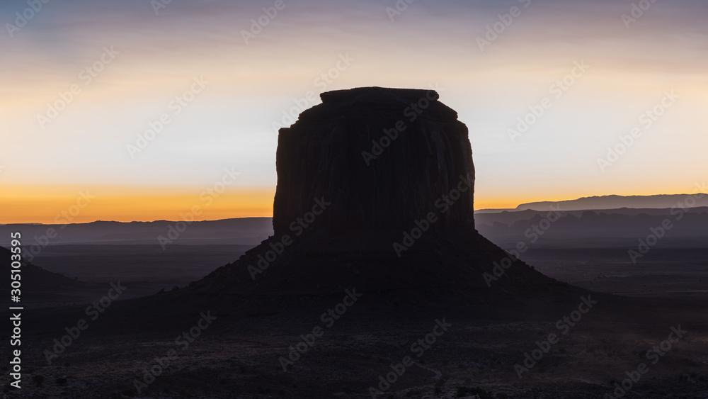 The first lights of the day and one of the Mitten Buttes in Monument Valley