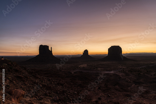 Hues of a colored sunrise over the Mitten Buttes in the Valley of the Monuments, Arizona.