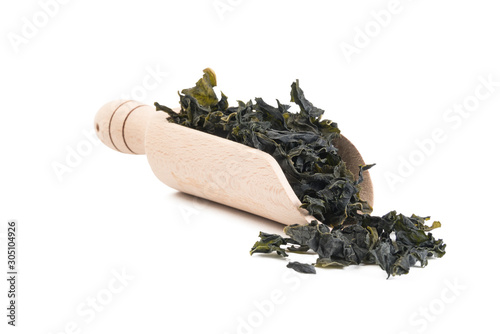 Dried kombu seaweed in wooden scoop isolated on white background. spices and food ingredients photo
