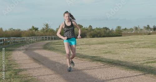 A teenage girl long distant runner starts to limp during training and her coach or father comes into the scene to check out the problem.