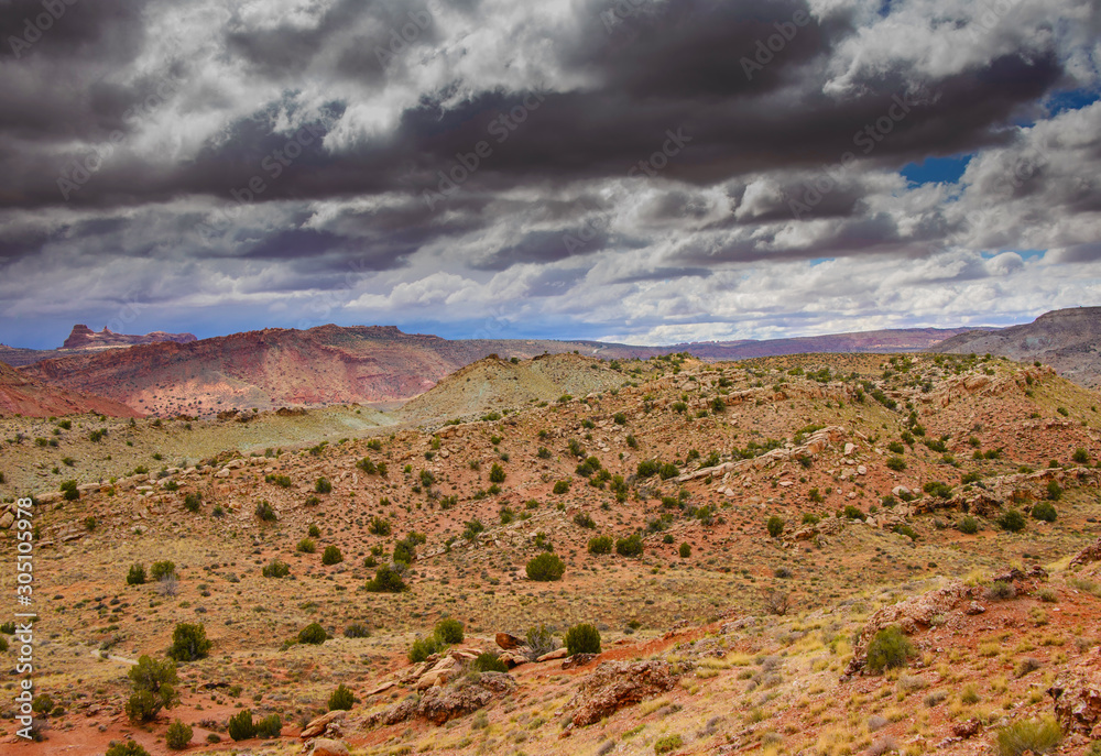 Rocky mountainsides under a cloudy sky in Arches National Park.