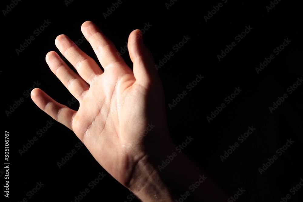 Men's palm in full dark under studio lighting, or 