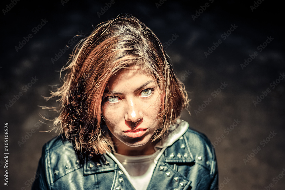 black-haired teenage girl with a displeased look on a black background black-haired teenage girl with a displeased look on a black background