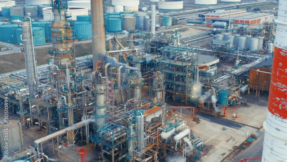 Aerial view of petrochemical oil refinery (refining complex). Oil and gas tanks with fuming pipes on the plant (factory) Aerial view of petrochemical oil refinery (refining complex). Oil and gas tanks with fuming pipes on the plant (factory)